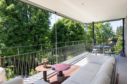 Gedeckte Terrasse mit Sitzgruppe und Blick ins Grün