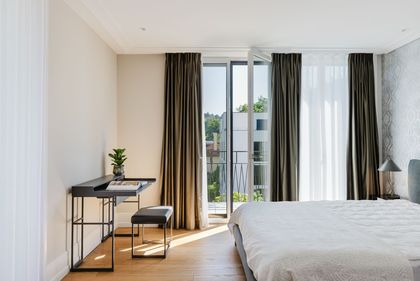 Schlafzimmer mit Arbeitsplatz und Balkonzugang