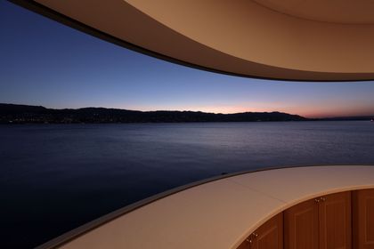 Blick über den Zürichsee in der Abenddämmerung, gerahmt von der geschwungenen Decke des Sitzplatzes